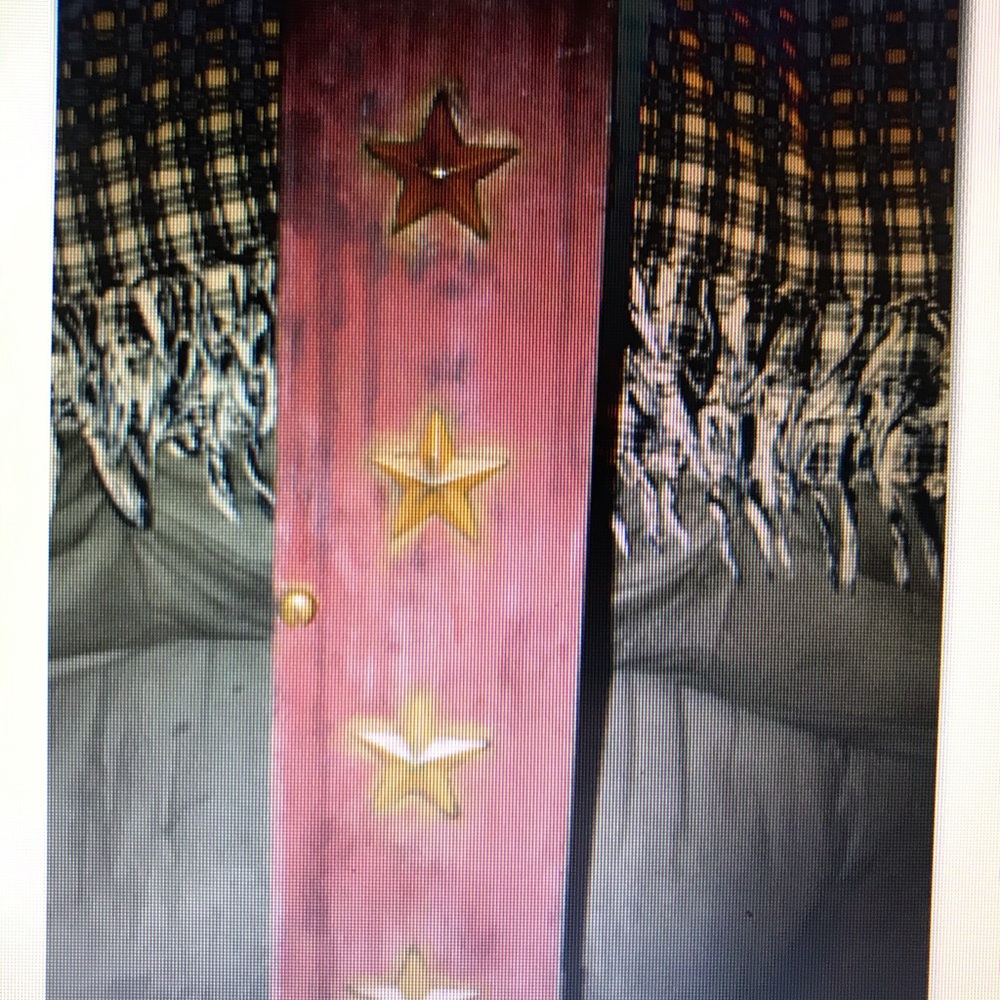 Burgundy toilet paper holder with mustard yellow stars.